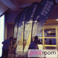 Printed feather flag with custom branded design outdoors.