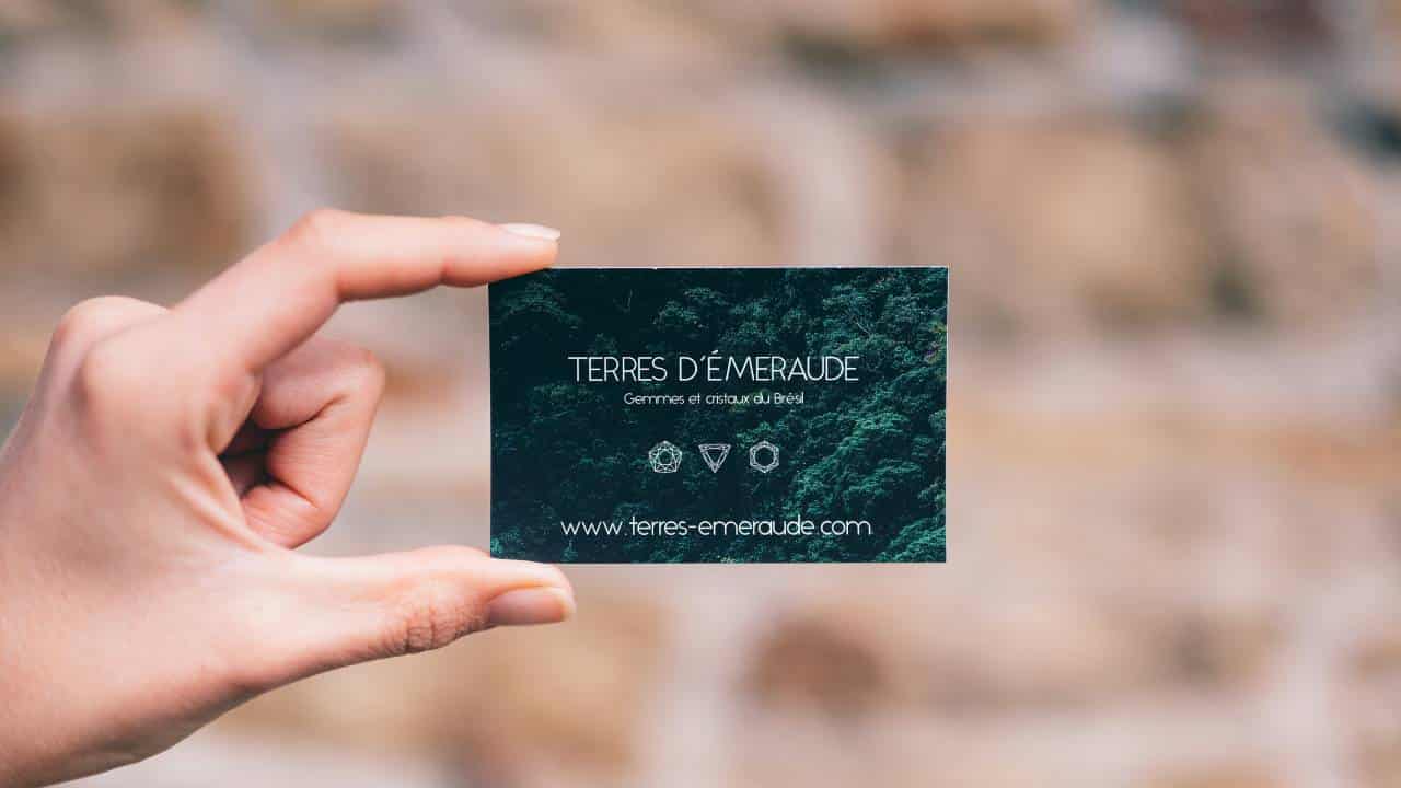 A woman holding a green business card