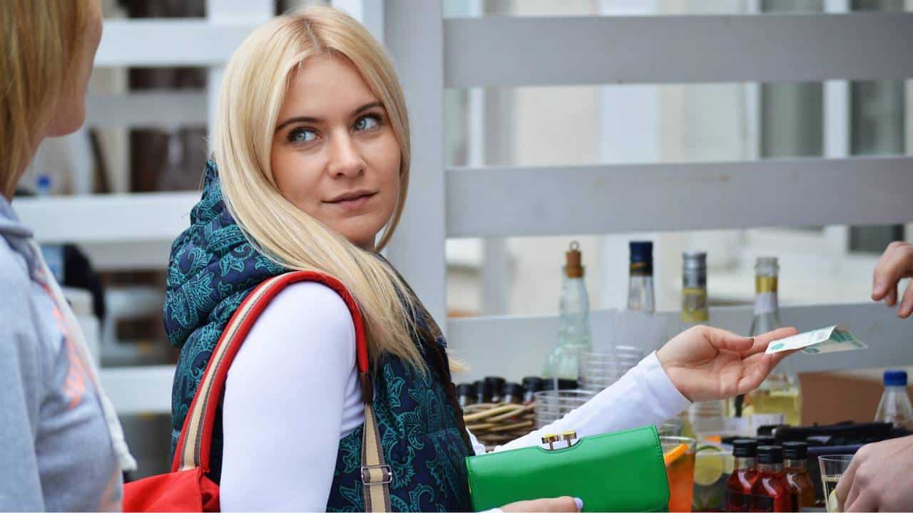 A blonde-haired female customer paying for products