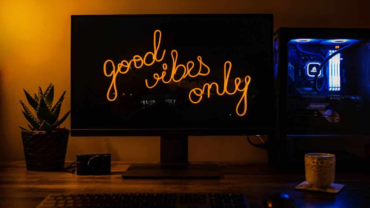A desktop monitor with a "good vibes only" catchphrase shown on its display