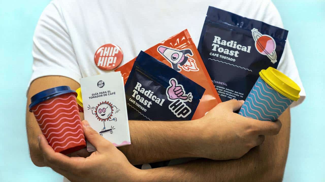 A person in a white shirt holding various coffee-related products