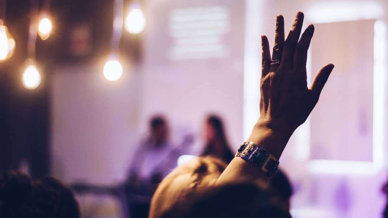 A woman raising her hand at a business event