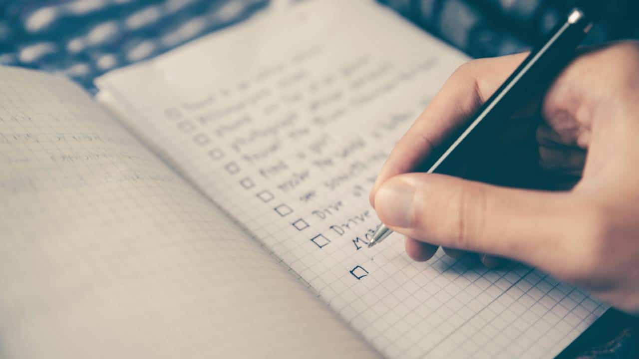 A person using a pen to write in a notebook