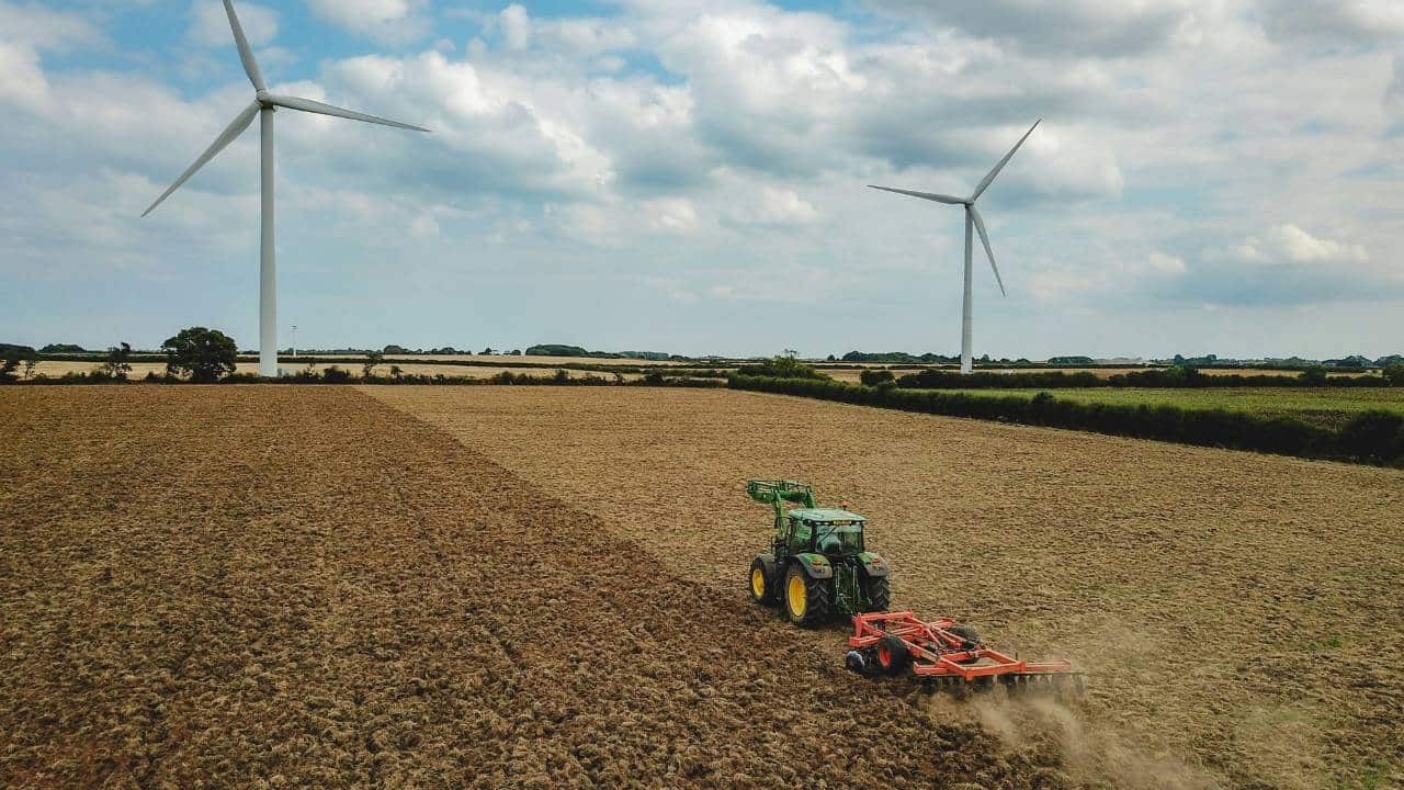 A tractor in a field ploughing the ground