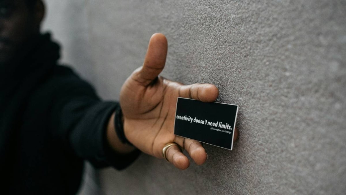 A photo of a man holding a black business card