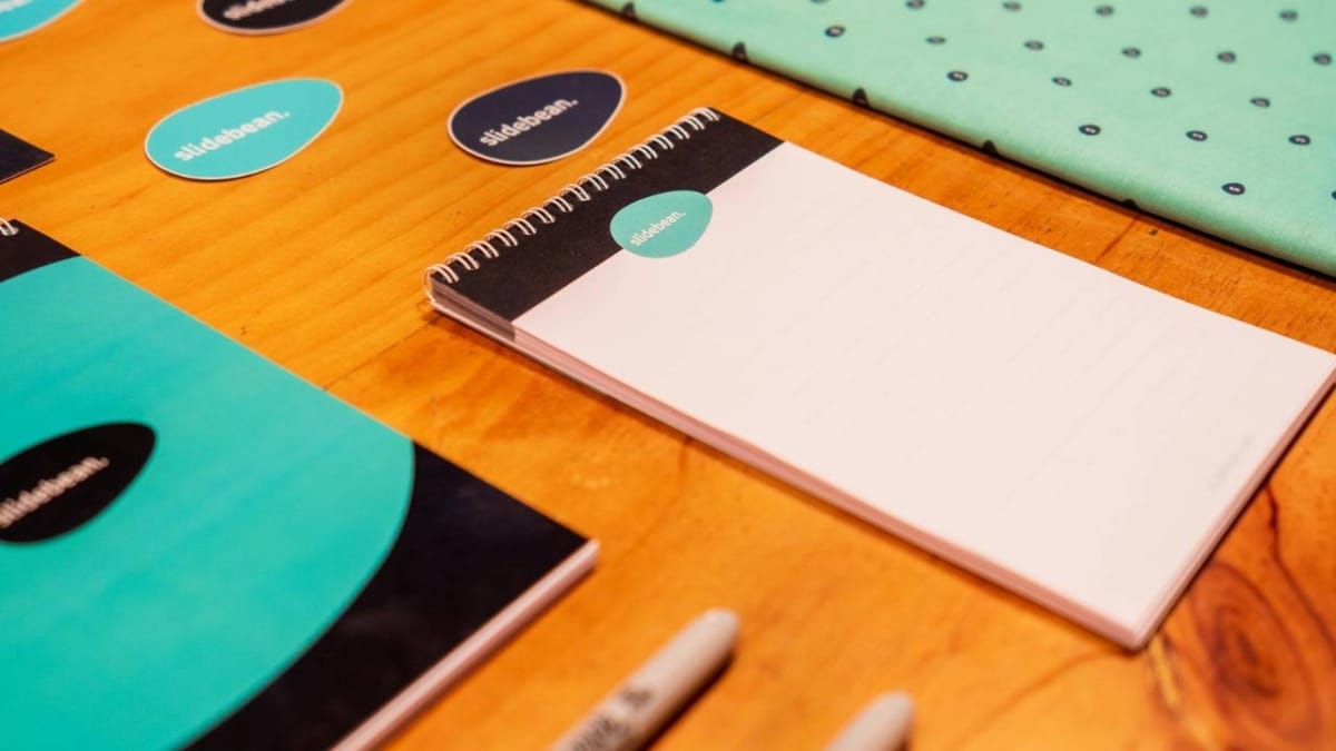 A photo of colourful notebooks, pens, and stickers placed on a table
