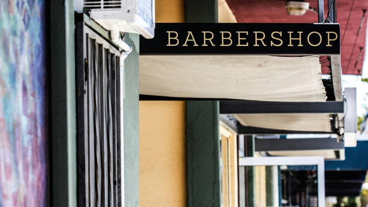 A storefront sign featuring the word "barbershop"